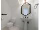 All white bathroom with pedestal sink, toilet, and decorative mirror at 1730 Point Pleasant Se, Smyrna, GA 30080