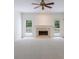Bright living room features a fireplace, ceiling fan, large windows and white carpet at 1730 Point Pleasant Se, Smyrna, GA 30080