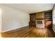 Cozy living room featuring hardwood floors, a wood-paneled fireplace, and custom built-in shelving at 2757 Shelley Ln, Ellenwood, GA 30294