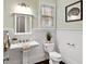 Charming bathroom with white wainscoting, classic fixtures, and a decorative mirror at 5160 Pratt Sw St, Covington, GA 30014