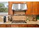 Close-up of a modern kitchen featuring stainless steel appliances, granite countertops, and wood cabinetry at 5160 Pratt Sw St, Covington, GA 30014