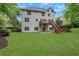 Well-maintained backyard featuring lush green grass, a deck, and a covered patio area, perfect for outdoor entertaining at 5435 Vicarage Walk, Alpharetta, GA 30005