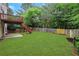 Lush green backyard with a spacious lawn, a covered patio and a wooden fence surrounding a private outdoor space at 5435 Vicarage Walk, Alpharetta, GA 30005