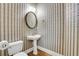 Bathroom features a toilet, patterned wallpaper and a vintage oval mirror at 5435 Vicarage Walk, Alpharetta, GA 30005