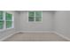 Bright bedroom with neutral walls, trim, and carpet; illuminated by natural light from two windows at 5435 Vicarage Walk, Alpharetta, GA 30005