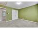 Neutral carpeted bedroom featuring a double closet with shelving at 5435 Vicarage Walk, Alpharetta, GA 30005
