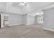 Large, carpeted bedroom featuring tray ceilings and multiple windows for natural light at 5435 Vicarage Walk, Alpharetta, GA 30005
