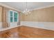 Refined dining space with hardwood floors, wainscoting, and a decorative chandelier at 5435 Vicarage Walk, Alpharetta, GA 30005