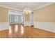 Bright dining room featuring hardwood floors, a chandelier, and a seamless flow to adjacent rooms at 5435 Vicarage Walk, Alpharetta, GA 30005