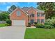Charming brick home with well-manicured lawn, two-car garage, and inviting front entrance at 5435 Vicarage Walk, Alpharetta, GA 30005