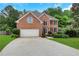Charming brick home with a well-manicured lawn, two-car garage, and welcoming front entrance, showcasing curb appeal at 5435 Vicarage Walk, Alpharetta, GA 30005