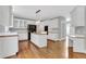 Kitchen boasts white cabinets, a kitchen island with cooktop, and hardwood floors at 5435 Vicarage Walk, Alpharetta, GA 30005