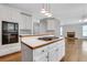 Modern kitchen features a cooktop island, white cabinets, and stainless steel appliances at 5435 Vicarage Walk, Alpharetta, GA 30005