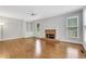 Bright living room with hardwood floors, a fireplace, built-in shelving, and large windows at 5435 Vicarage Walk, Alpharetta, GA 30005