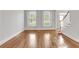 Open living room with hardwood floors, large windows, and bright, neutral walls at 5435 Vicarage Walk, Alpharetta, GA 30005