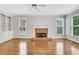 Bright living room featuring hardwood floors, a brick fireplace, and a ceiling fan at 5435 Vicarage Walk, Alpharetta, GA 30005
