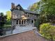 Rear exterior featuring a deck, gray siding, a triangle window, and a brick chimney at 990 Azalea Dr, Roswell, GA 30075