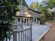 Back exterior of house with a wooden deck, gray siding, large windows and green trees at 990 Azalea Dr, Roswell, GA 30075