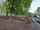 Expansive backyard with mature trees, pine straw ground cover, and a trellis structure at 990 Azalea Dr, Roswell, GA 30075