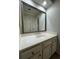 Bathroom vanity with shaker cabinets, silver hardware, white marble counter, and framed mirror at 990 Azalea Dr, Roswell, GA 30075