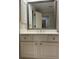 Elegant bathroom vanity featuring shaker cabinets, silver hardware, and large framed mirror at 990 Azalea Dr, Roswell, GA 30075