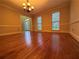 Large dining room has hardwood floors, three windows with mini-blinds, neutral color scheme and attractive chandelier at 990 Azalea Dr, Roswell, GA 30075