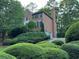Brick home surrounded by lush greenery, showcasing a well-manicured landscape at 990 Azalea Dr, Roswell, GA 30075