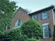 Brick home featuring black shutters, manicured bushes, and a gable accent window at 990 Azalea Dr, Roswell, GA 30075