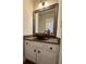 Powder room featuring a brown bowl sink with decorative mirror and white cabinets at 990 Azalea Dr, Roswell, GA 30075