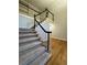 Carpeted staircase with white railings and dark trim leading to an upper level at 990 Azalea Dr, Roswell, GA 30075