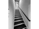 View of stairway with black painted steps, white risers, and black handrail at 990 Azalea Dr, Roswell, GA 30075
