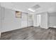Open basement features gray wood flooring, white walls, windows, and a bathroom access at 6307 Thornhedge Dr, Riverdale, GA 30296