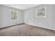 This cozy bedroom features two windows offering natural light and neutral carpeting at 6307 Thornhedge Dr, Riverdale, GA 30296