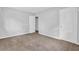 Bright bedroom with neutral carpeting, two white doors, a window, and fresh paint at 6307 Thornhedge Dr, Riverdale, GA 30296
