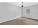 Cozy bedroom featuring neutral paint, carpet, large windows, and a classic light fixture at 6307 Thornhedge Dr, Riverdale, GA 30296