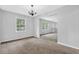 Bright living room featuring neutral paint, cozy carpet, and large windows offering ample natural light at 6307 Thornhedge Dr, Riverdale, GA 30296