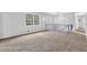 Bright living room featuring neutral paint, cozy carpet, and large windows offering ample natural light at 6307 Thornhedge Dr, Riverdale, GA 30296