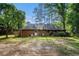 Backyard with brick home, green grass, and mature trees at 801 Sugar Creek Se Trl, Conyers, GA 30094