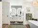 Modern bathroom with double vanity, sleek mirrors, soaking tub, and stylish chandelier at 801 Sugar Creek Se Trl, Conyers, GA 30094