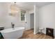 Bright bathroom featuring soaking tub, chandelier, and wood flooring at 801 Sugar Creek Se Trl, Conyers, GA 30094