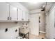 Bright laundry room features a utility sink, washer/dryer hookups, and ample cabinet storage at 801 Sugar Creek Se Trl, Conyers, GA 30094