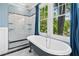 Bright bathroom featuring a freestanding tub, shower, and large windows, offering a relaxing and refreshing retreat at 1028 Amsterdam Ne Ave, Atlanta, GA 30306