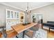 Open dining area with wooden table, modern chairs, built-in cabinet, and seamless flow to the living room at 1028 Amsterdam Ne Ave, Atlanta, GA 30306