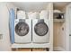 Functional laundry room with modern washer and dryer units, ample storage shelves, and an ironing board at 1028 Amsterdam Ne Ave, Atlanta, GA 30306