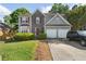 Charming two-story home featuring stone accents, a well-manicured lawn, and an attached two-car garage at 5077 Newpark Nw Dr, Acworth, GA 30101