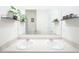 Bathroom featuring double sinks, quartz countertops, wall shelves, large mirror, and plant decorations at 5344 Flat Rock Pt, Stonecrest, GA 30038