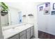Bathroom with double sinks, large mirror, quartz countertop, grey cabinets, and wall decorations at 5344 Flat Rock Pt, Stonecrest, GA 30038