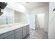 Bathroom featuring double sinks, gray cabinets, quartz countertops, a large mirror, and tiled floors at 5344 Flat Rock Pt, Stonecrest, GA 30038