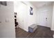 Entryway with hardwood floors, gray bench, white door, and artwork at 5344 Flat Rock Pt, Stonecrest, GA 30038
