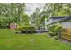 Lush backyard featuring a green lawn, mature trees, a pool and deck with an outdoor shed at 1615 Arden Sw Dr, Marietta, GA 30008